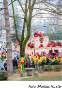 ein Karnevalswagen mit vielen kostümierten Menschen